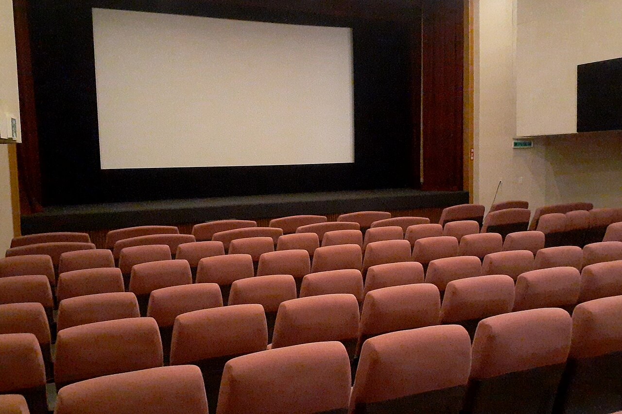 Interior of a movie theater with rows of seats facing the screen (illustrative photo)